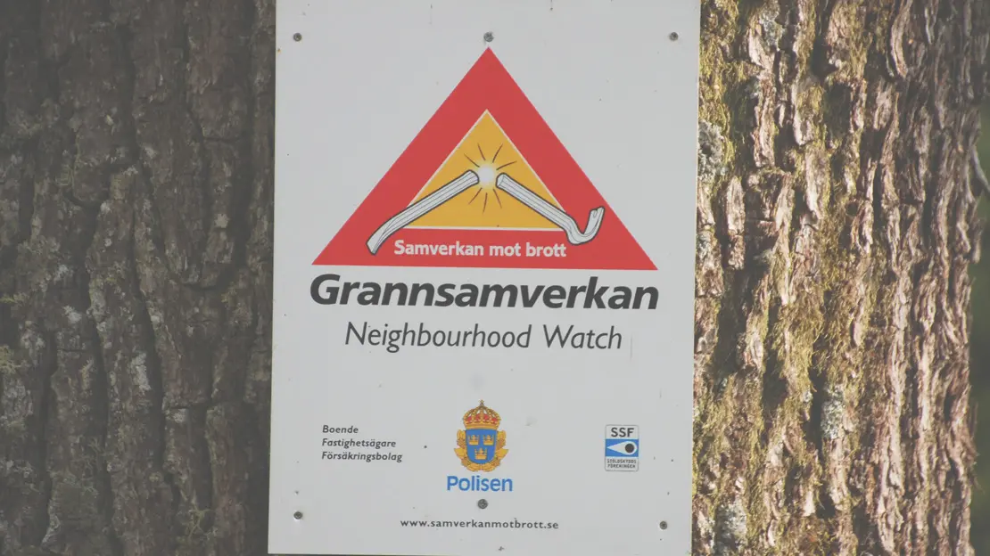 grannsamverkan skylt på en trädstam