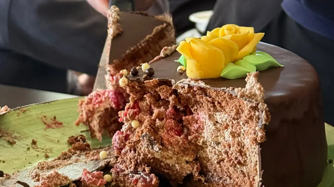 Närbild inuti en chokladtårta. Någon tar av en liten bit ifrån den.