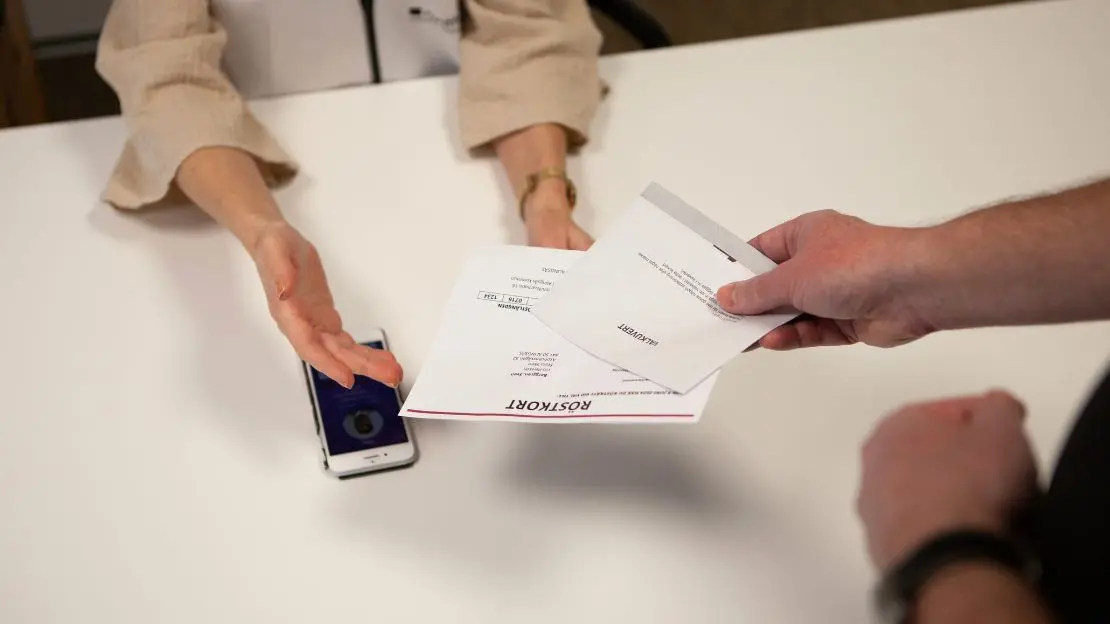 Person överlämnar sina röstkort
