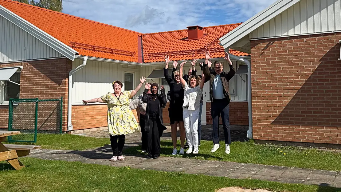 Kortis Lambo medarbetare står utanför huset och hoppar med händerna mot himlen.