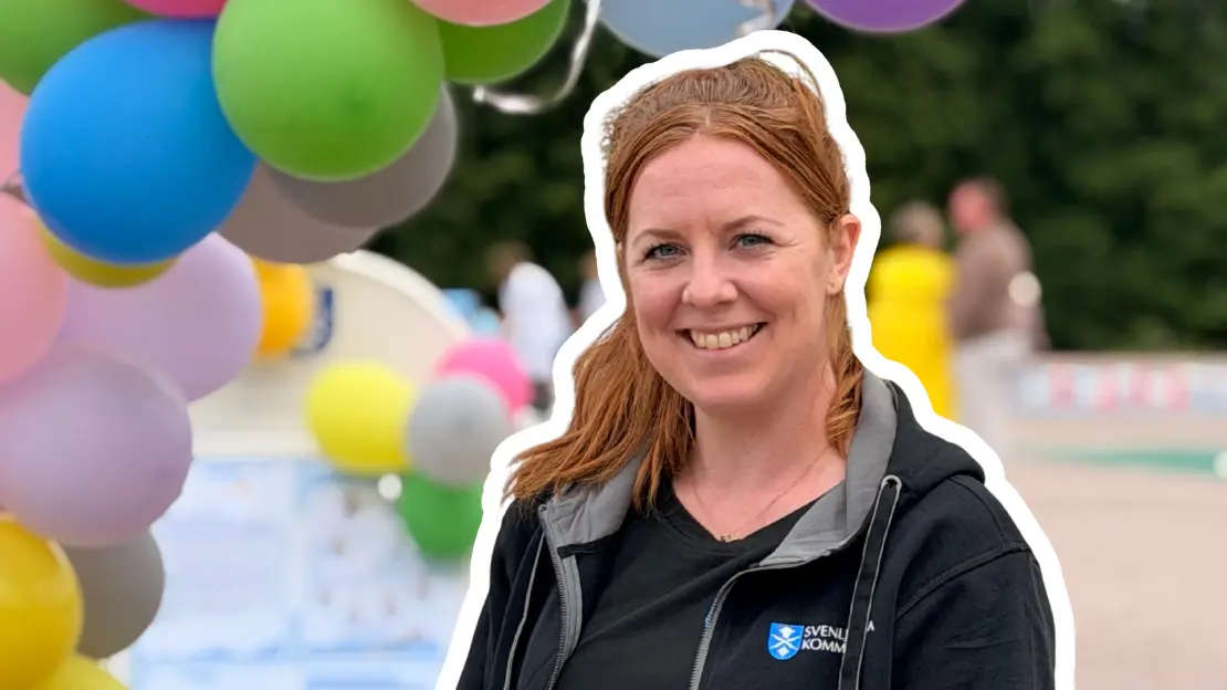 Elinore  ler och är glad framför färgranna ballonger.