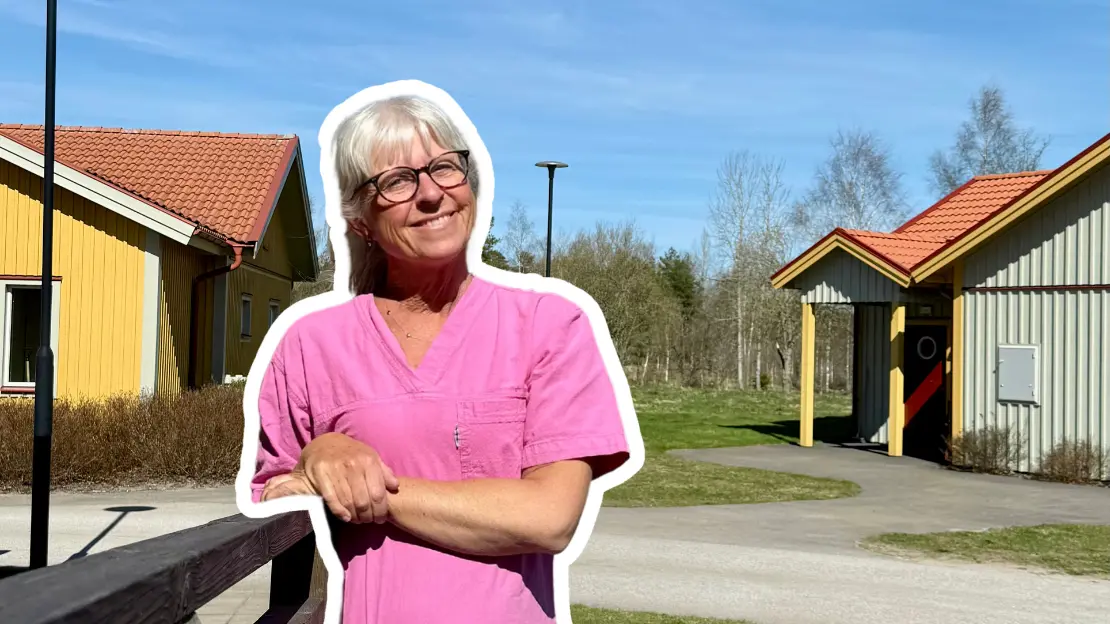 Helena är glad och ler framför två husbyggnader. 