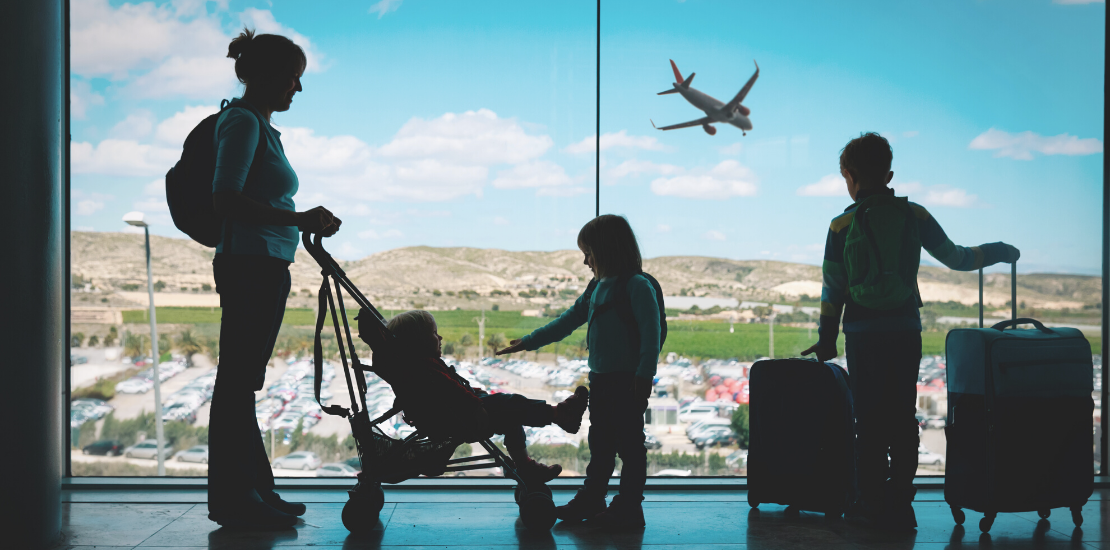 förälder med 3 barn står på flygplats