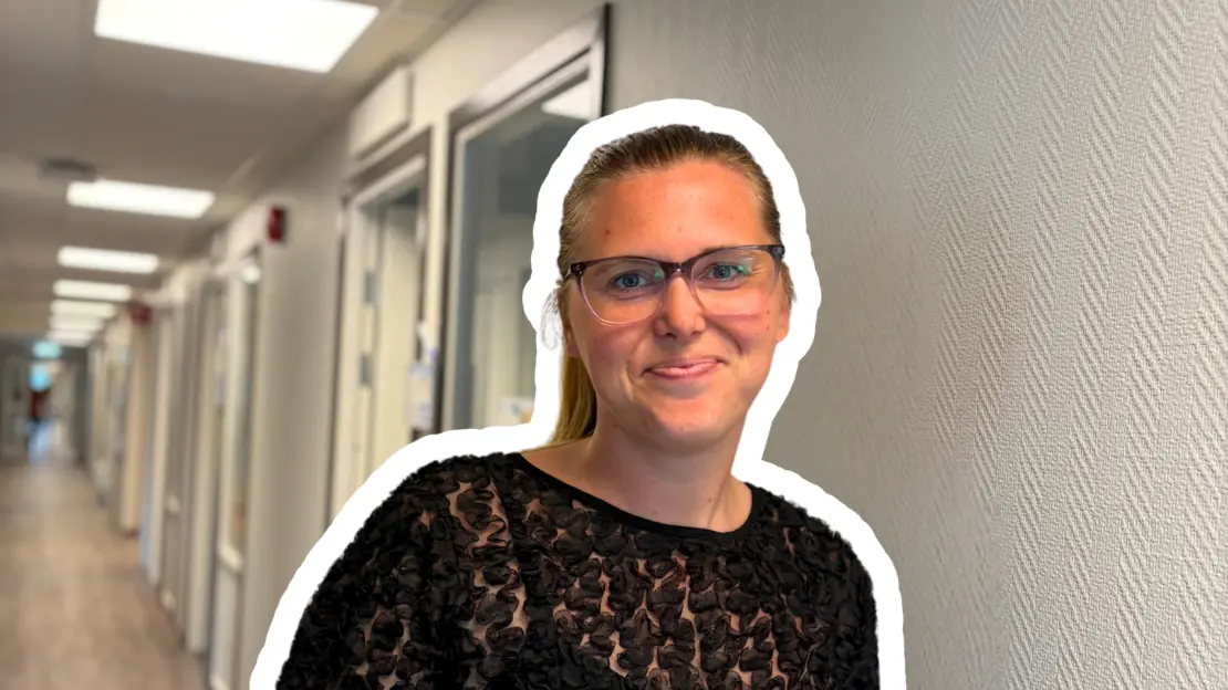 Emma Nyman står i kanslikorridoren och ser glad ut och ler in i kameran.