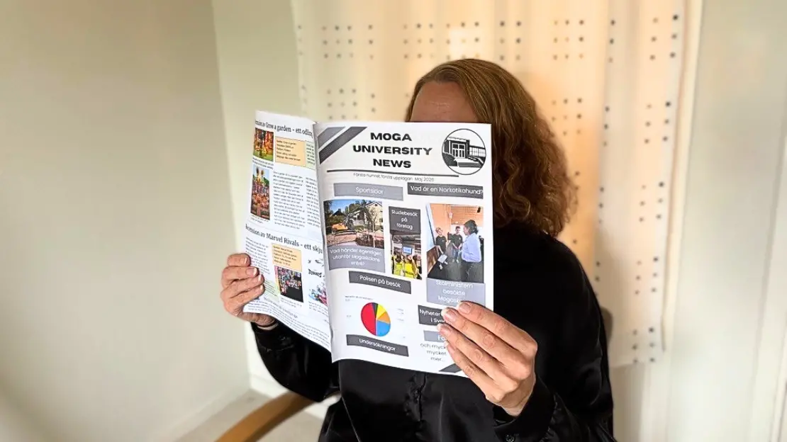 Person sitter och läser tidningen Moga University News.