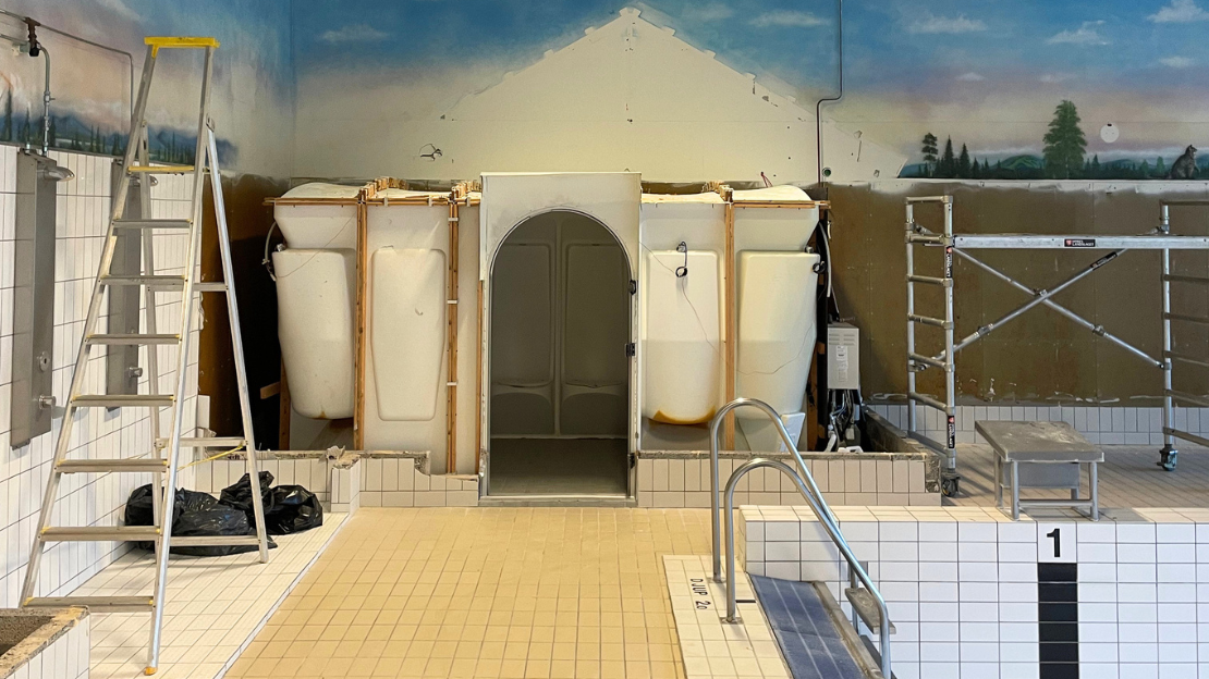till höger i bilden är en tom simbassäng och väggen bakom renoveras