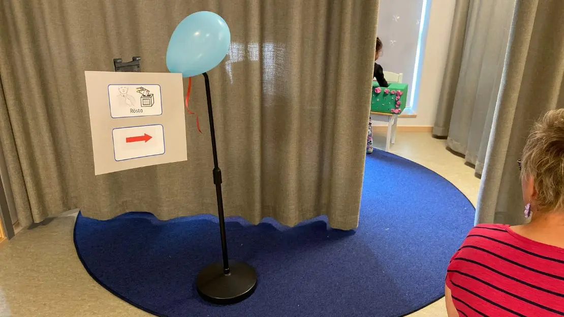 Ett barn lägger ner sin röst i en valurna.