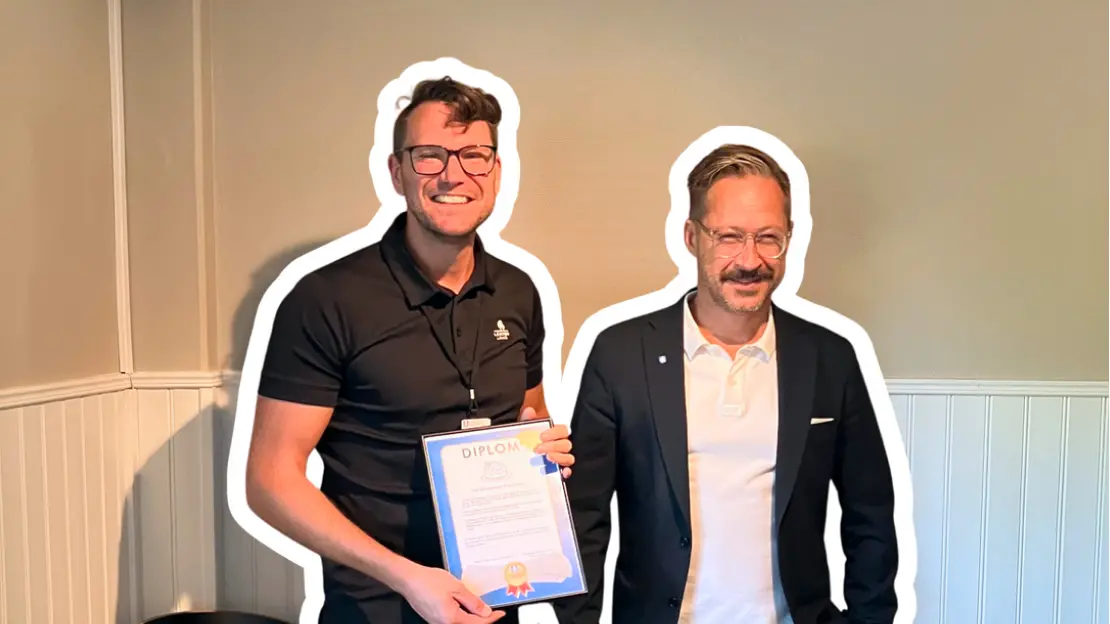 Chrsitoffer Österling och Sebastian Nyden ser glada ut. Christoffer håller upp ett diplom. Båda bär glasögon.