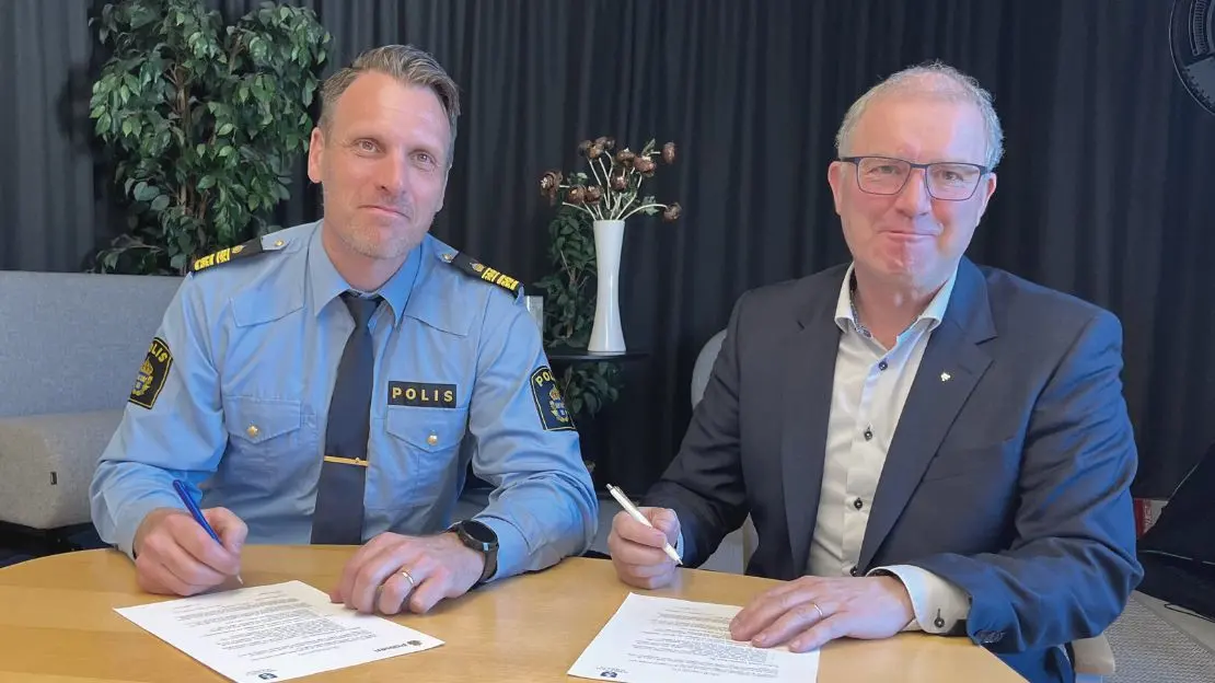 polis och KSO sitter vid bord och skriver under ett papper.
