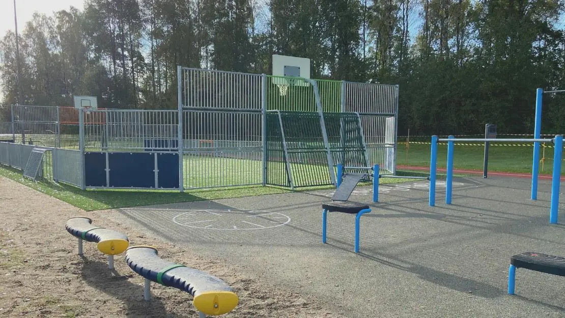Plats med olika typer av sportutrustning såsom klätterställning och basketkorg.
