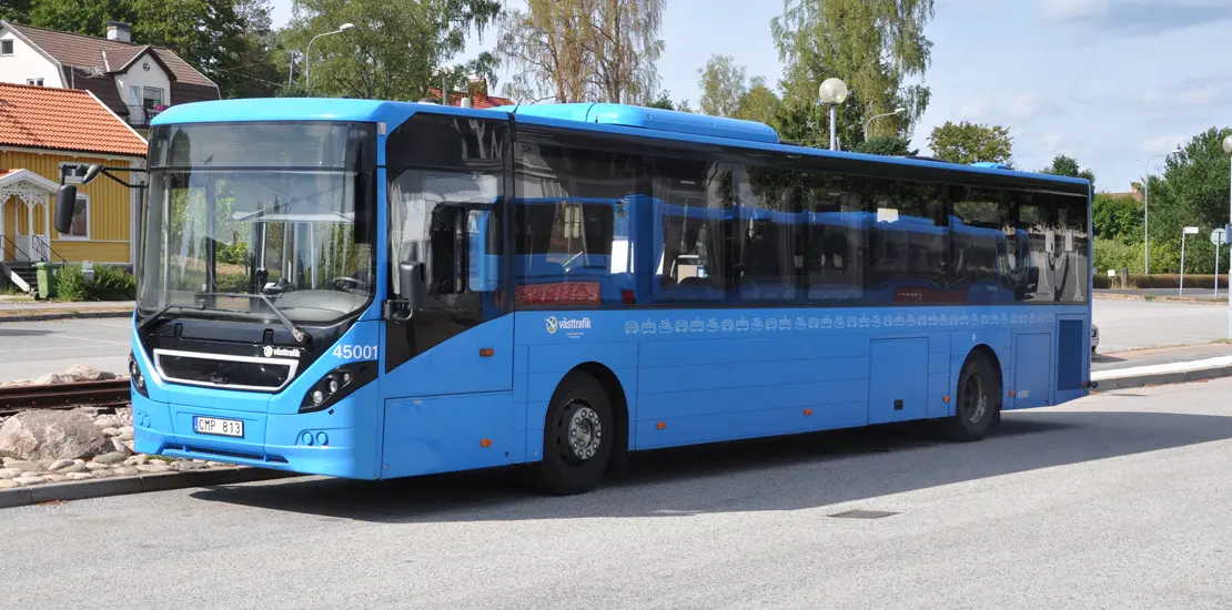 Blå Västtrafik buss står vid busshållplatsen i Svenljunga centrum.