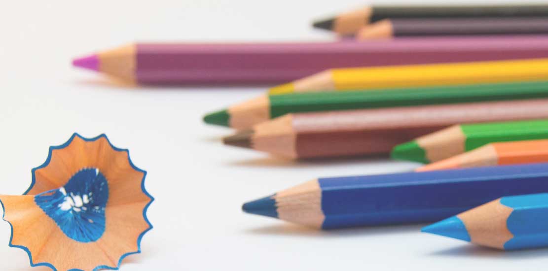Olika färgpennor som ligger på ett bord