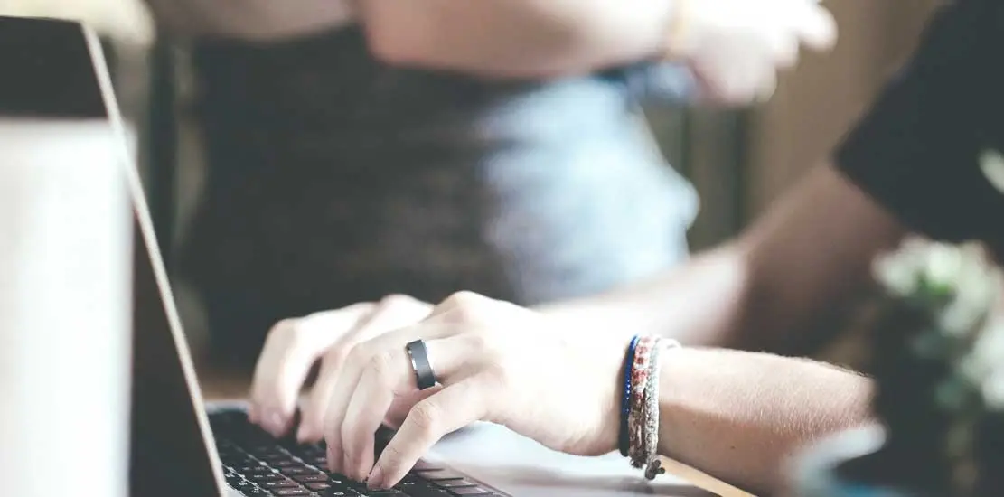 Någon som sitter vid en laptop och skriver