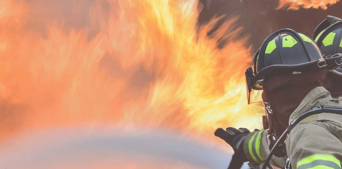 två brandmän som värkar stressade med att släcka en brand