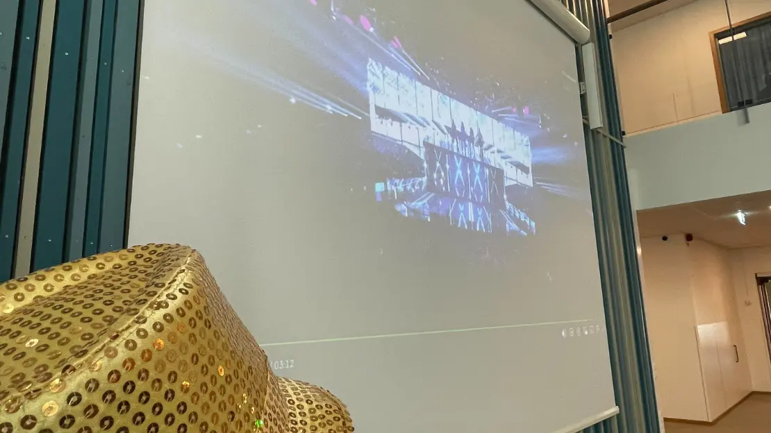 elev med glittrig hatt som tittar på melodifestivalens bidrag