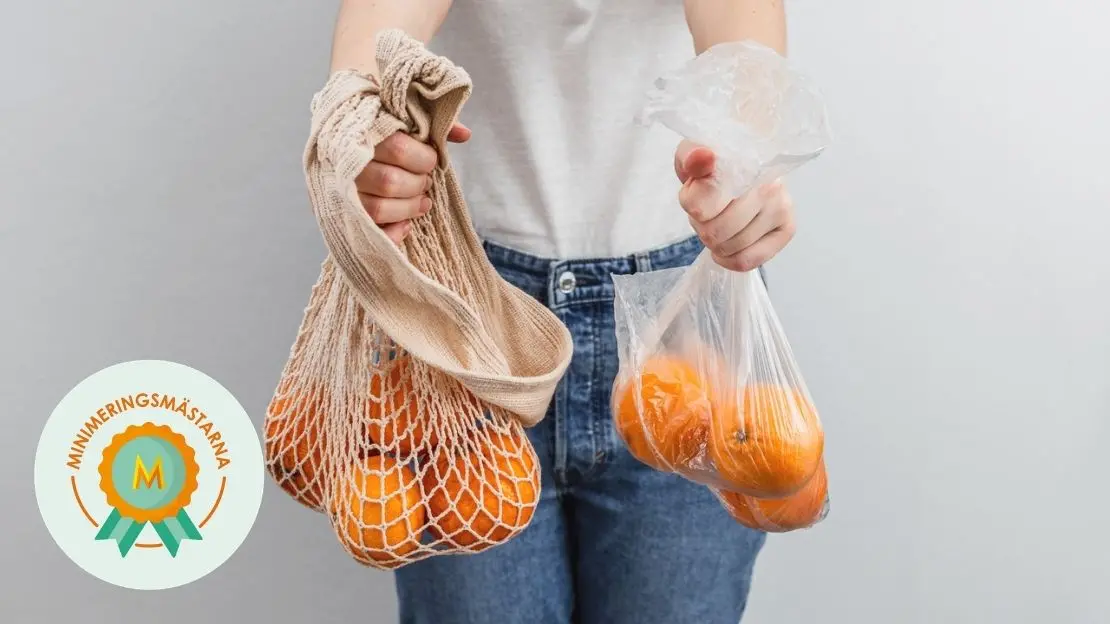 person håller två kassar med apelsiner. den ena kassen är gjord i plast och den andra kassen är återanvändbar
