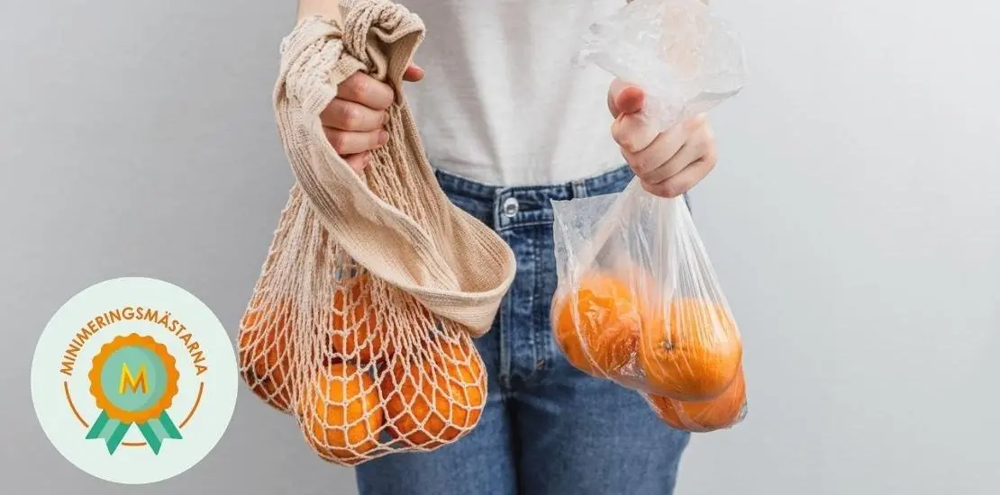 person håller två kassar med apelsiner. Den ena kassen är gjord av plast och den andra kassen är en flergångskasse