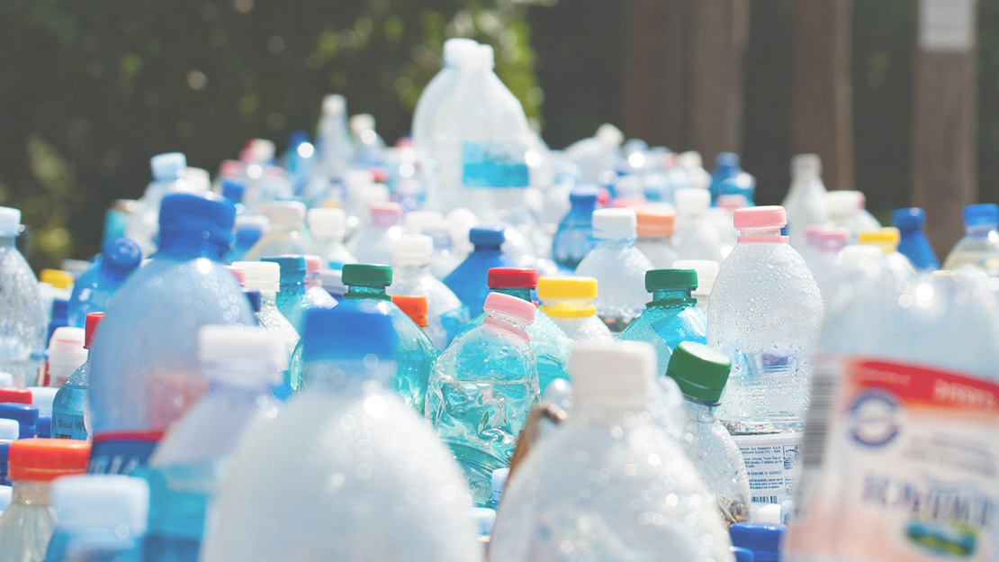 Bild på massor av plastflaskor stående i ögonhöjd. Länken leder till sida som beskriver vad du kan slänga på återvinningsstationer.