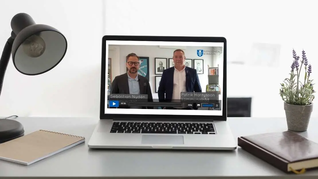 Laptop står öppen på skrivbord, videospelare syns.