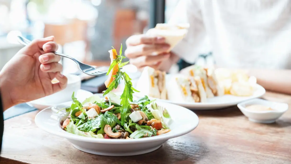 Två personer äter lunch tillsammans.