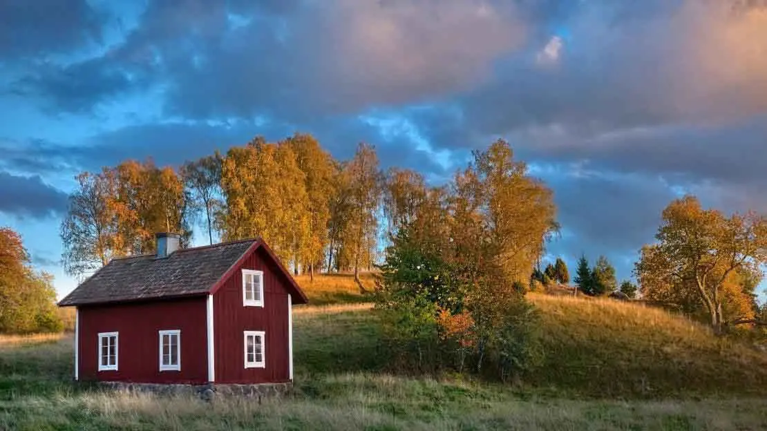 Falurött torp i höst landskap.