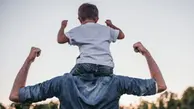 Ryggen på en vuxen som håller armarna uppåt som visar styrka. På axlarna sitter en pojke som också håller armarna upp och visar styrka.