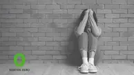 Person sitter på golvet med armarna framför ansiktet. I hörnet finns loggan för Suicide Zero.