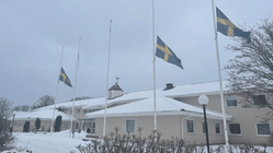 kommunhuset i snö, svenska flaggan på halvstång