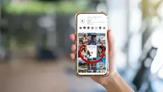 En suddig bakgrund. I förgrunden syns en hand som håller i en mobil. På skärmen syns profilsidan för kommunens instagram.
