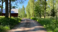 En grusväg jämte en lada i en landsbygd. 