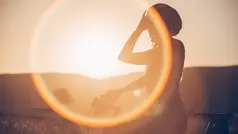 Person står vid cykel i kvällssol