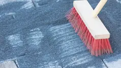 mycket grus på gatstenar sopas bort av röd sopborste 