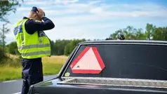 En polisman står jämte en A-traktor.