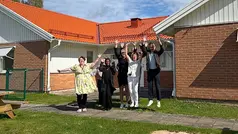 Kortis Lambo medarbetare står utanför huset och hoppar med händerna mot himlen.