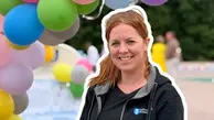 Elinore  ler och är glad framför färgranna ballonger.