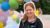 Elinore  ler och är glad framför färgranna ballonger.