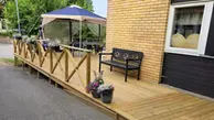 Den nya uteplatsen på Gullviva, Klockaregården är pyntad med parasoll, blommor och bänk. 