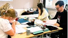 Lärare sitter runt ett bord och rättar prov.