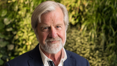 Professor Gunnar Bjursell står framför en vägg av växter. 