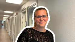 Emma Nyman står i kanslikorridoren och ser glad ut och ler in i kameran.
