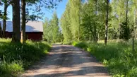 En grusväg jämte en lada i en landsbygd. 