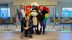 Tjuris, Johan och Patrik står med Pride-flaggan. Sebastian står på ett knä framför. 