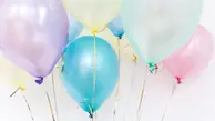 många färggranna ballonger fastknutna i varsitt snöre