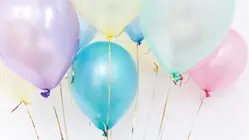 många färggranna ballonger fastknutna i varsitt snöre