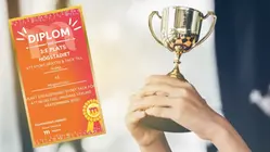 två händer lyfter upp en pokal, bredvid finns ett diplom