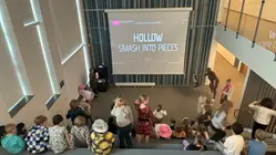 elever sitter i en gradängtrappa och tittar på melodivestivalens bidrag