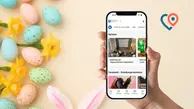 En hand håller upp en mobil där invånarappen syns på skärmen, i bakgrunden är loggan för invånarappen, påskägg, påskliljor och kaninöron.