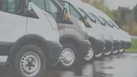 rad med transportbilar, bara främre delen syns, alla är vita förutom den andra från vänster som är grå